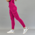 Jogger quirúrgico mujer 905 fucsia, vista lateral en movimiento con bolsillos de parche en el muslo y puños en los tobillos