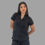 Women's black Style 930 scrub top, three-quarter view with hands behind back