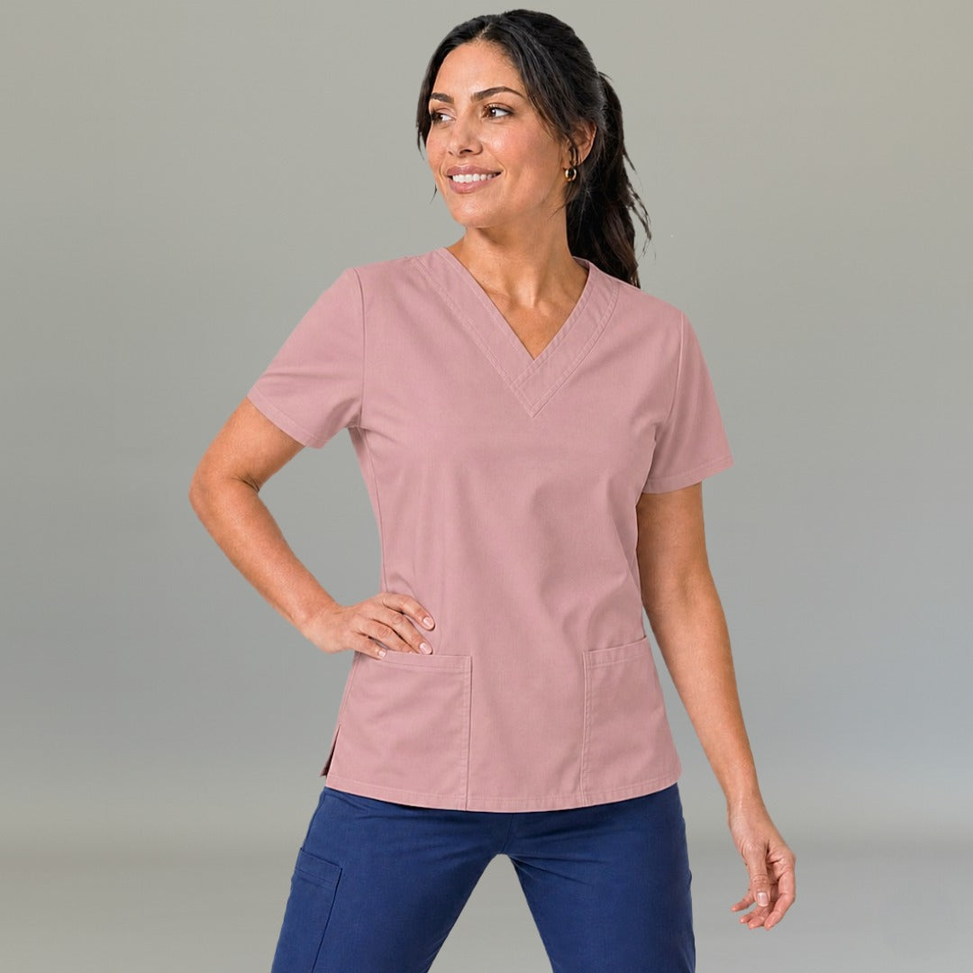 Mujer luciendo filipina 502 color rosa oscuro, vista frontal con manos en la cadera.