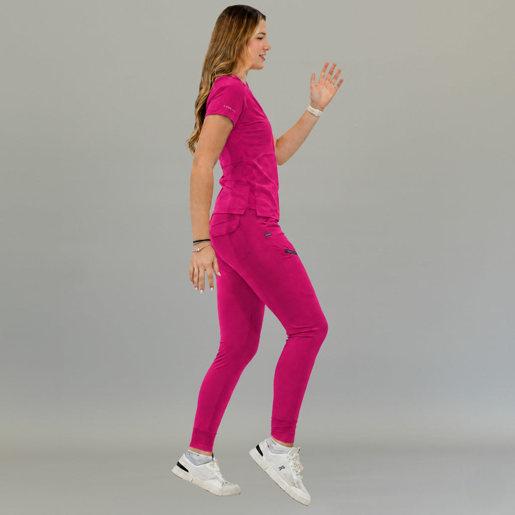Jogger quirúrgico mujer 905 fucsia, vista lateral de una modelo caminando con bolsillos laterales y puños en los tobillos