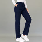 Mujer modelando pantalón 502 quirúrgico azul marino en vista tres cuartos, mostrando pierna amplia.